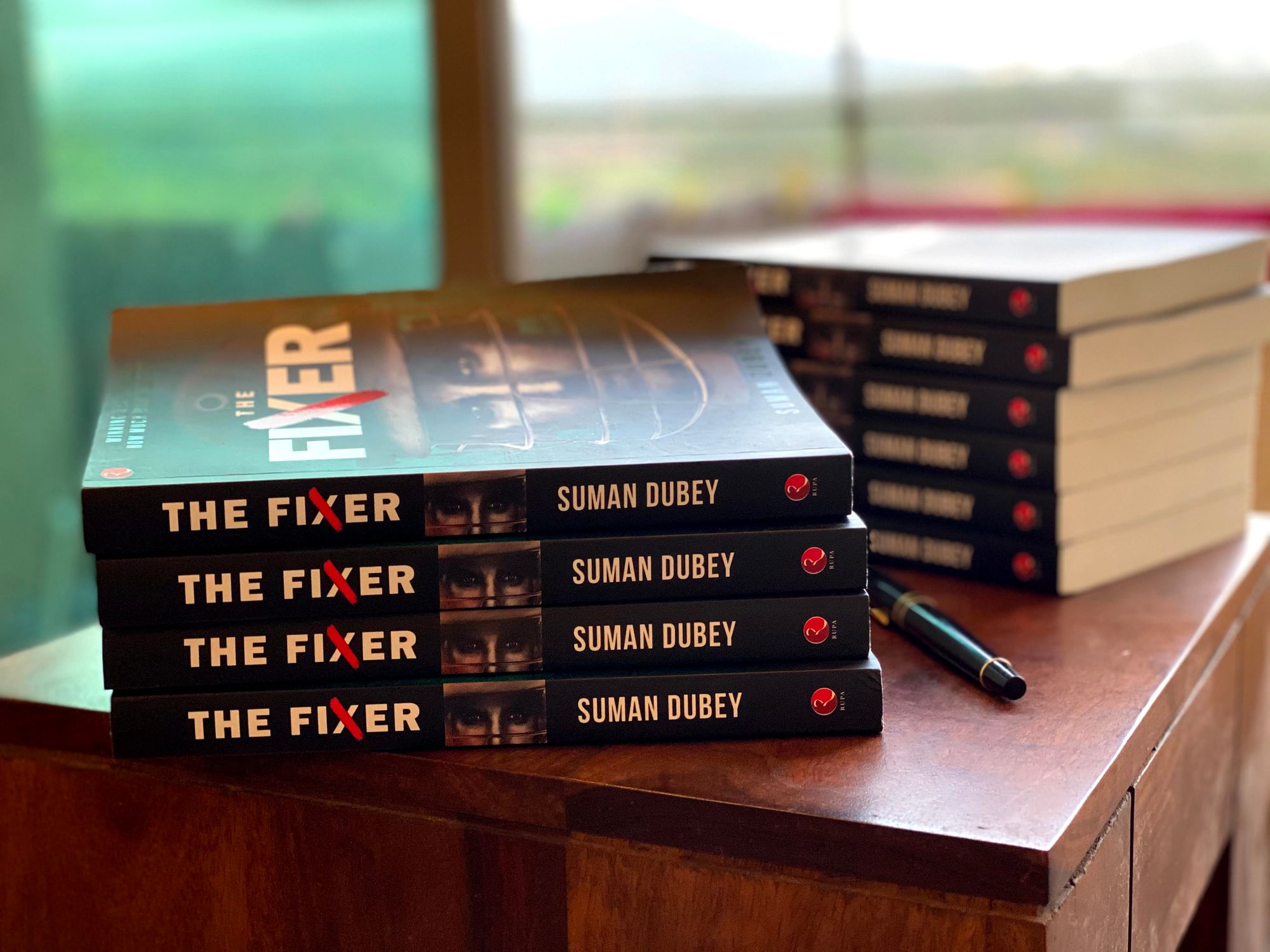 Image showing two stacks of Suman Dubey’s first book “The Fixer”.  